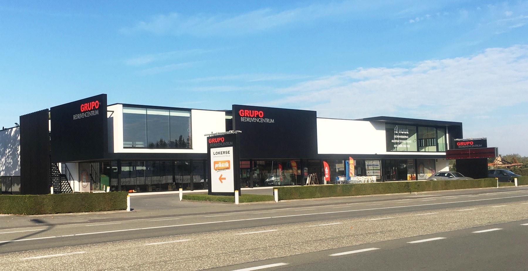 Gevel van het Grupo bedrijvencentrum met verlichte signalisatie